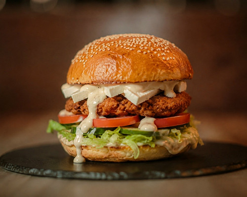AVE Burger — Микс салатов цезарь и греческий между двумя горячими булочками. Курица в панировке, помидоры, свежий огурчик,  лист салата, сыр фета и соус цезарь.